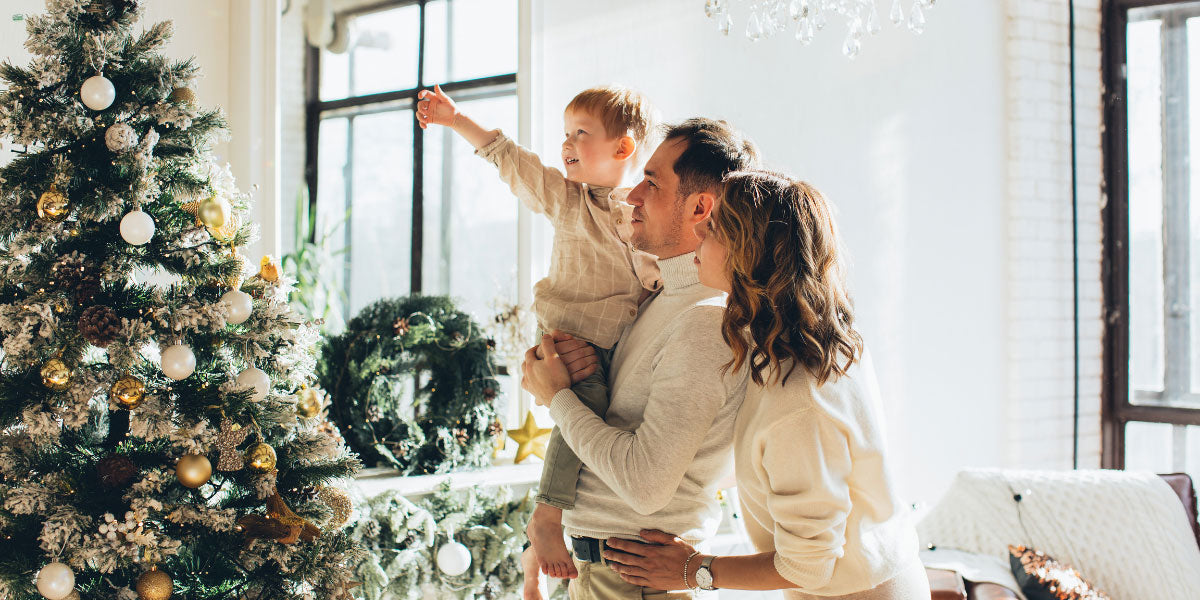 Familie schmückt Tannebaum.